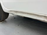 a white car that has a dent in the side of it