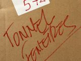 une boîte en carton sur laquelle est posée une pancarte, posée au sommet d'une pile de boîtes