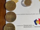 five coins sitting on a piece of paper on a table