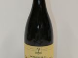 La bouteille de vin rouge est posée sur une table blanche.