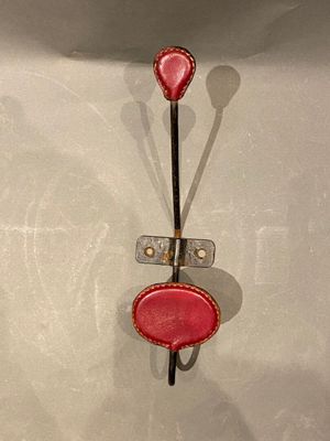 un objet rouge accroché à un crochet au mur