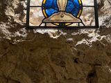 a stained glass window in the middle of a stone wall