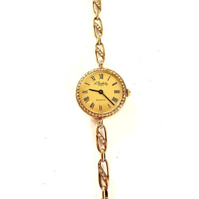 une montre en or avec une chaîne, sur fond blanc