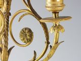 a gold candle holder with a bird on top of it