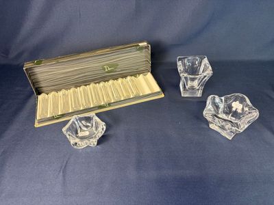 a set of four glass candlesticks and a box