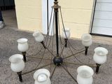 a chandelier made out of glass with a black vase on top