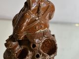 a statue of a bird sitting on top of a skull