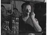 photographie en noir et blanc d'un homme assis à une table devant un miroir