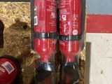 two red fire extinguisors sitting on top of a cardboard box