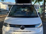 the back end of a white vw van with its hood open