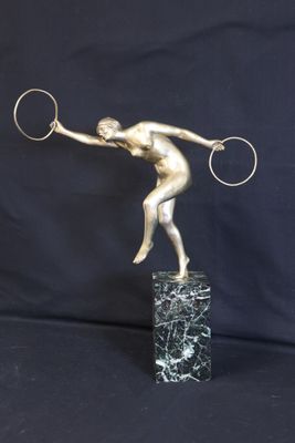 bronze statue of a tennis player holding a racket on a marble base