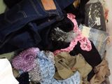 a pile of clothes in a plastic container on the floor