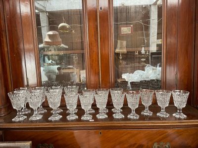 de nombreux verres posés sur une étagère en bois devant une fenêtre