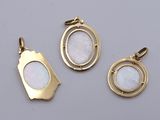 three gold plated pendants with a white mother of pearl in the center