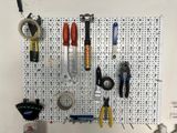 a pegboard with tools hanging on it in a garage