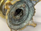 a close up of a brass object on a white surface