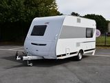 une photo d'un camping-car blanc garé sur un parking