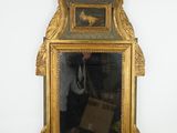 un miroir avec un cadre doré et un homme qui se prend en photo dedans