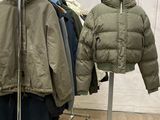 deux vestes suspendues à un portant dans un magasin de vêtements