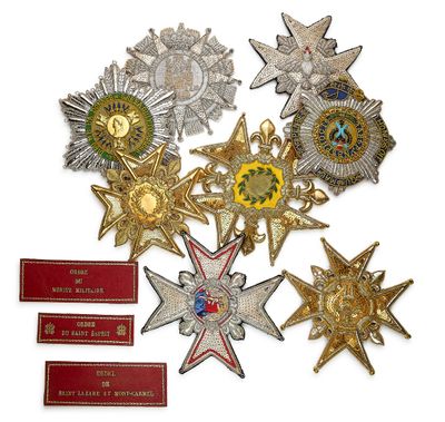 Plusieurs médailles et plaques sont exposées sur un support blanc