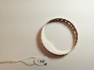 a white bracelet with a tag on it on a table