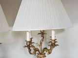 pair of antique lamps on a table in a room with a white wall