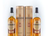 three bottles of whisky are sitting next to each other on a white surface