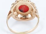 an image of a gold ring with a red stone in the center