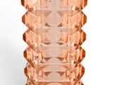a pink glass vase with a yellow label on it