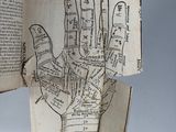 an open book with a drawing of a hand on it