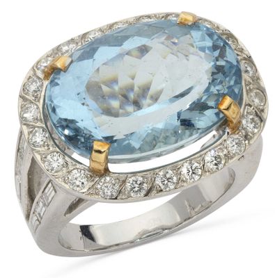 a close up of a ring with a blue topaz stone surrounded by diamonds