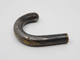 a close up of a black and gold pipe on a white surface