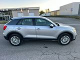 a silver suv parked in a parking lot next to a building