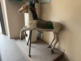 a wooden horse with a helmet on it ' s head