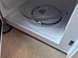 a microwave with a lid open on the floor