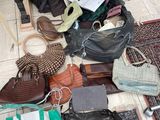 a pile of purses on the floor next to a table