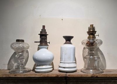 quatre bouteilles en verre posées les unes à côté des autres sur une étagère