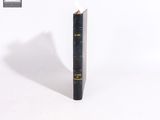 un vieux livre d'où sort un crayon, posé sur une surface blanche