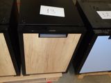 three black and white refrigerators sitting in a warehouse