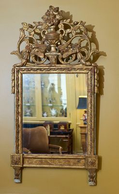 Glace à fronton ajouré en bois mouluré, sculpté et doré. Il …