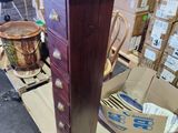 a tall wooden chest of drawers in a warehouse