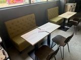 tables and chairs in a room with a large window and a book shelf