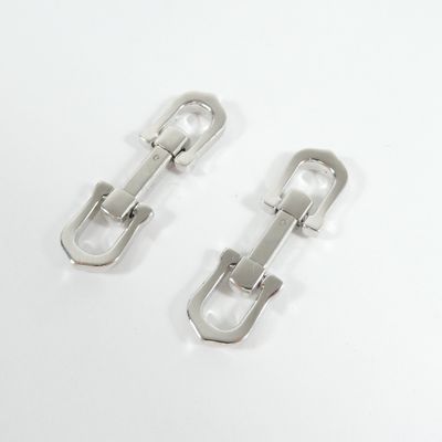 pair of silver metal buckles on a white surface
