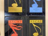 four books on a shelf with a picture of a musical note on them
