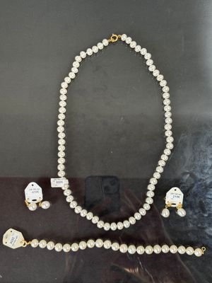 un gros plan sur un collier et des boucles d'oreilles exposés dans une vitrine