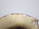 a close up of a brown and white vase on a table