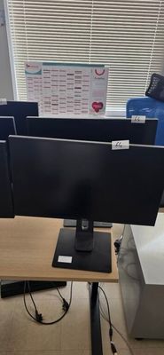 a desk with two monitors and a keyboard on it