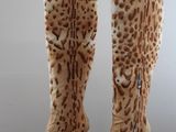 pair of women ' s leopard print boots on a black table