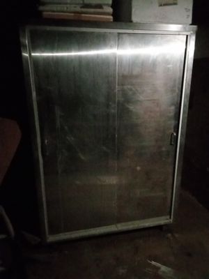 une armoire métallique munie d'une porte, dans une pièce sombre