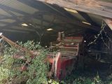 an old truck that is sitting under a roof